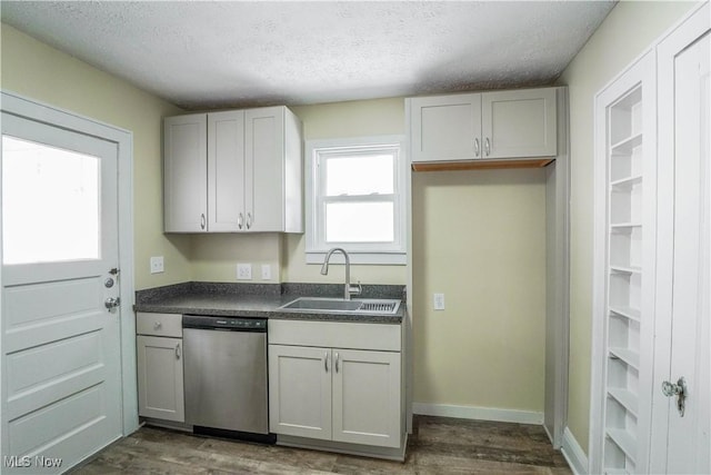 kitchen featuring dark hardwood / wood-style flooring, a textured ceiling, stainless steel dishwasher, white cabinets, and sink