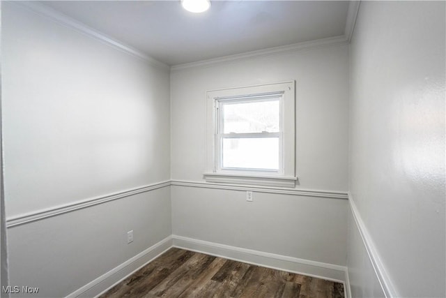 empty room with dark hardwood / wood-style flooring and ornamental molding