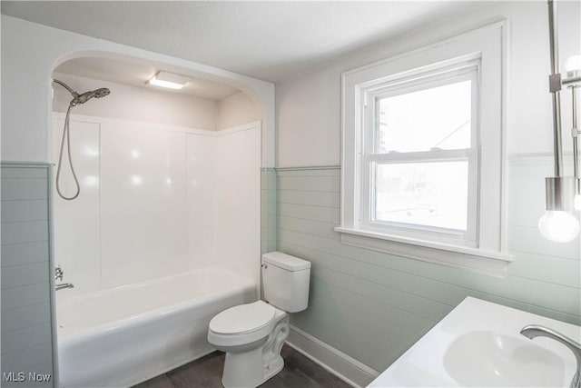 full bathroom featuring toilet, tub / shower combination, wood-type flooring, and vanity