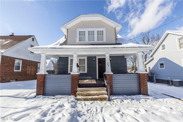 bungalow-style house with central AC unit and a porch