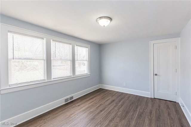 unfurnished room with dark wood-type flooring