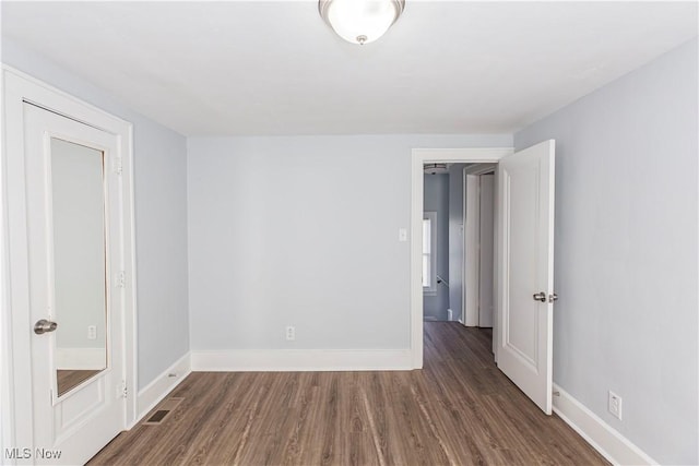 empty room with dark hardwood / wood-style floors