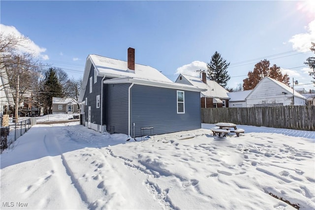 view of snow covered back of property