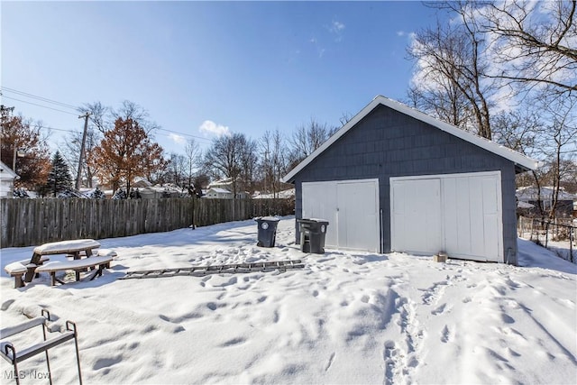 yard covered in snow featuring an outdoor structure and a garage