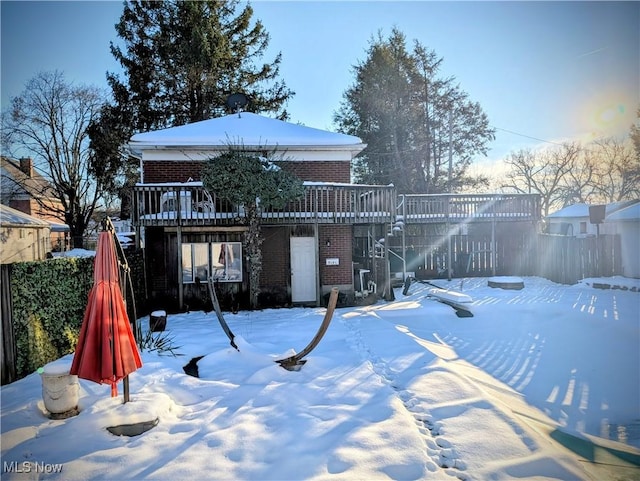 snowy yard featuring a wooden deck