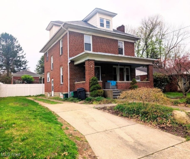 914 27th St, Parkersburg, WV 26104 - american foursquare style home featuring a porch, a front lawn, fence, and brick siding