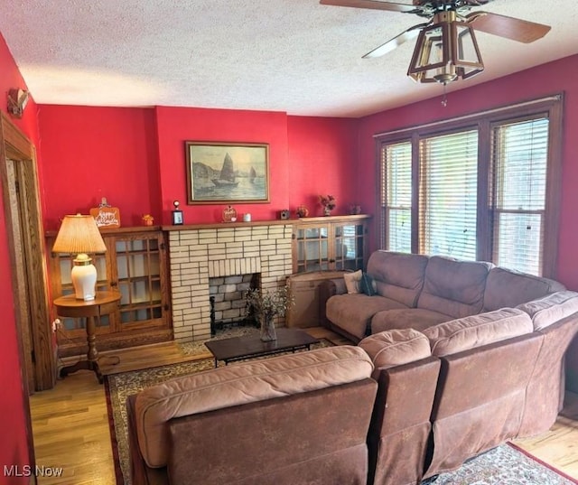 914 27th St, Parkersburg, WV 26104 - living area featuring a fireplace, wood finished floors, a textured ceiling, and a ceiling fan