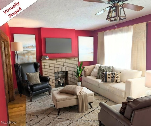 914 27th St, Parkersburg, WV 26104 - living area featuring ceiling fan, wood finished floors, a textured ceiling, and a fireplace