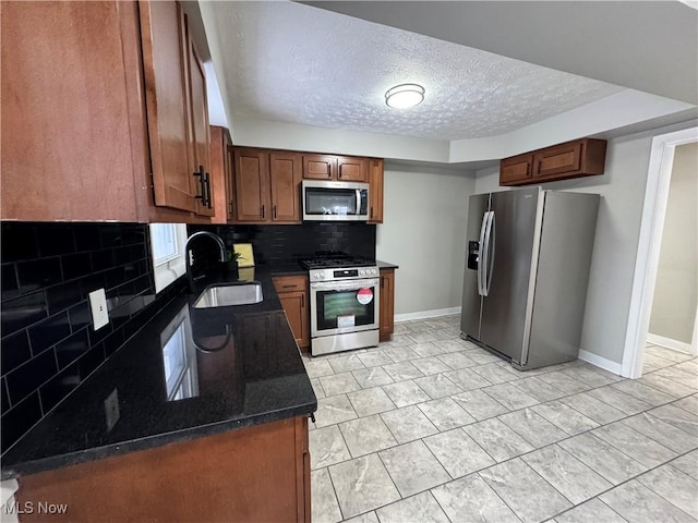 kitchen featuring a textured ceiling, appliances with stainless steel finishes, backsplash, and sink