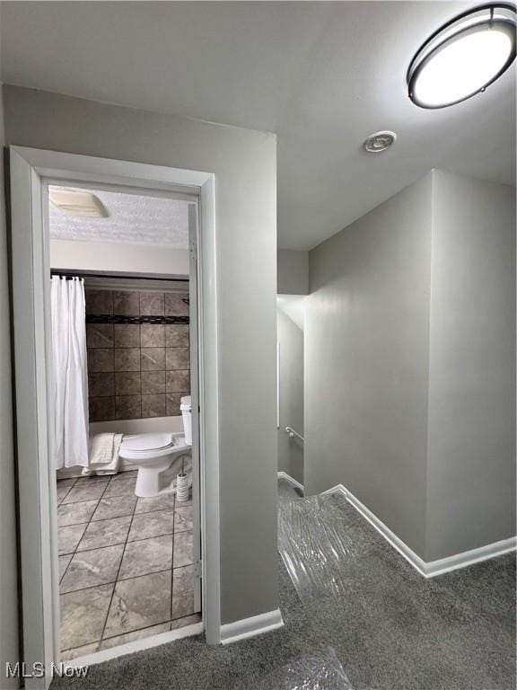 bathroom with curtained shower and toilet