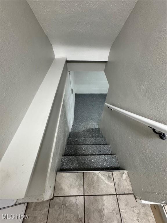 stairs with a textured ceiling