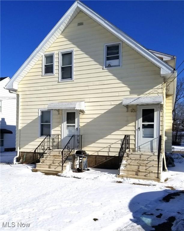 view of snow covered back of property