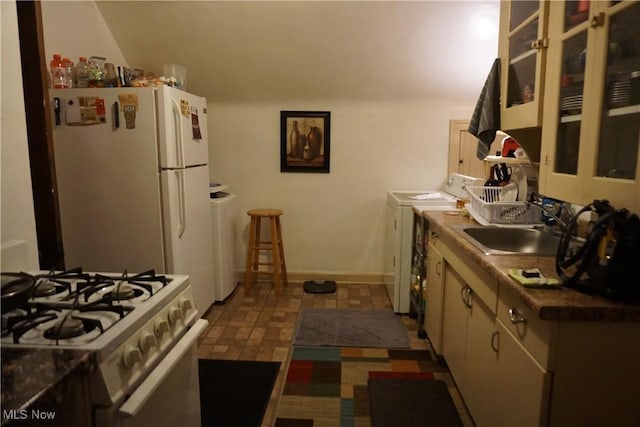 kitchen with sink, white appliances, and washer / dryer