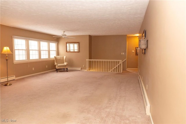 unfurnished room with a baseboard heating unit, a textured ceiling, and carpet flooring