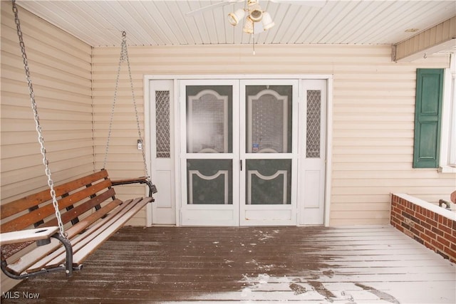 view of exterior entry featuring a wooden deck