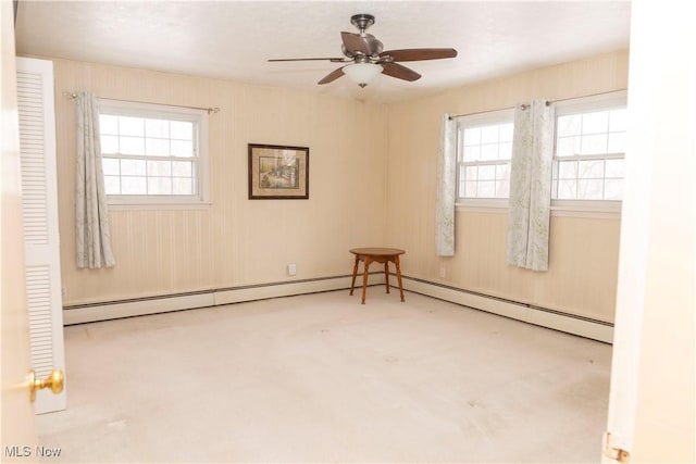 unfurnished room with ceiling fan, a healthy amount of sunlight, light colored carpet, and baseboard heating