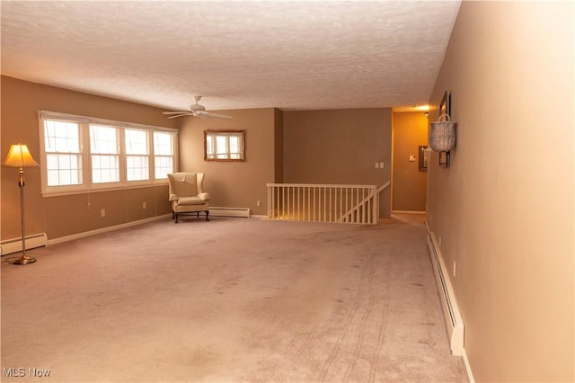 unfurnished room with ceiling fan, light colored carpet, a textured ceiling, and baseboard heating