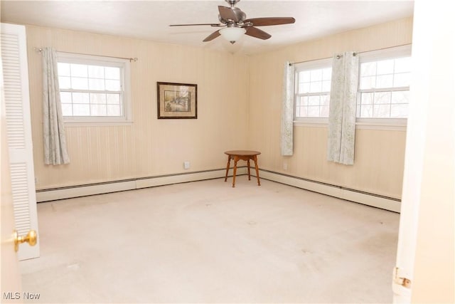 empty room with light carpet, ceiling fan, and baseboard heating