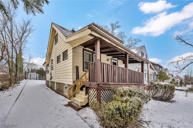 view of snowy exterior featuring covered porch