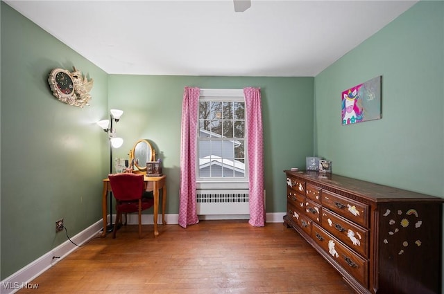 sitting room with wood-type flooring and radiator heating unit