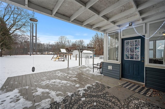 snow covered deck featuring a playground