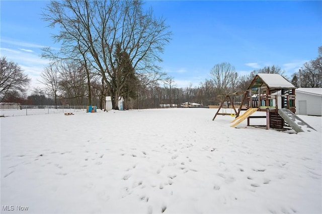 yard covered in snow with a playground