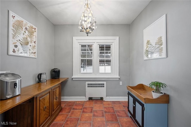 office with radiator heating unit and a notable chandelier