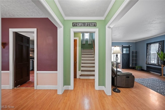 staircase featuring radiator, wood-type flooring, a textured ceiling, and ornamental molding