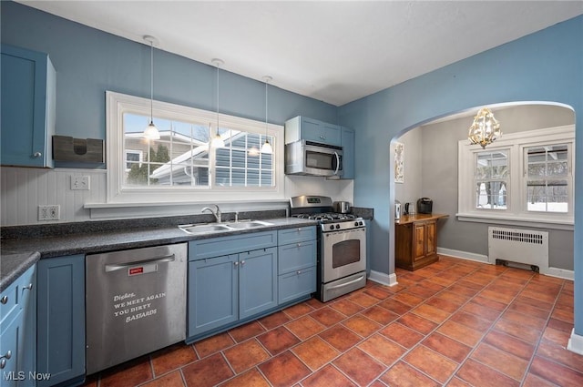 kitchen featuring radiator, appliances with stainless steel finishes, sink, and blue cabinets