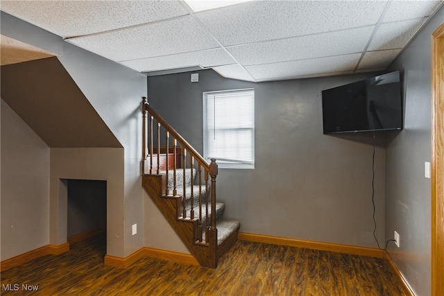 staircase featuring a paneled ceiling and hardwood / wood-style floors