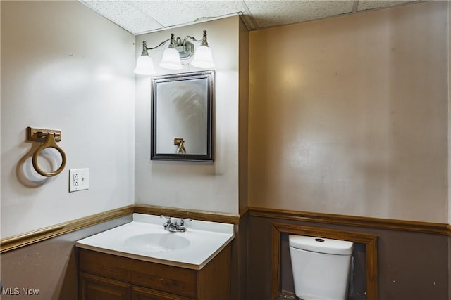 bathroom featuring vanity, a paneled ceiling, and toilet