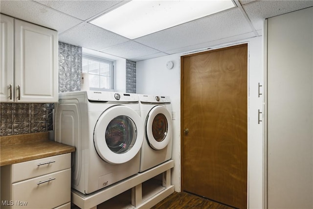 clothes washing area featuring independent washer and dryer, dark hardwood / wood-style floors, and cabinets