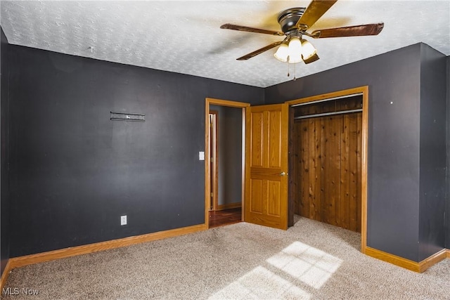 unfurnished bedroom featuring ceiling fan, a closet, light carpet, and a textured ceiling