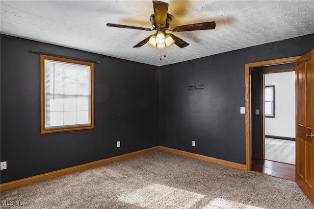 carpeted spare room with ceiling fan and a textured ceiling