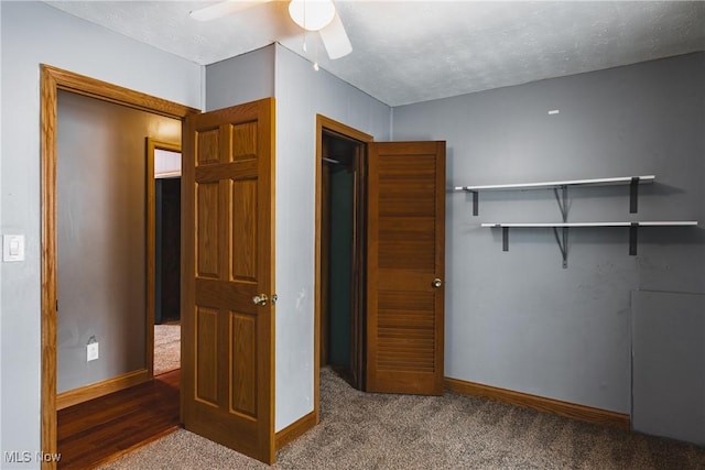 unfurnished bedroom featuring ceiling fan, carpet floors, and a textured ceiling