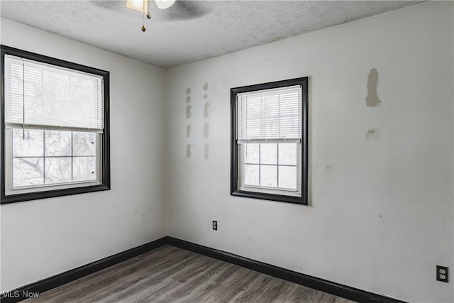 spare room featuring ceiling fan, dark hardwood / wood-style flooring, and a textured ceiling