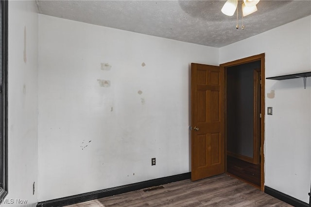 unfurnished room featuring dark hardwood / wood-style flooring and a textured ceiling