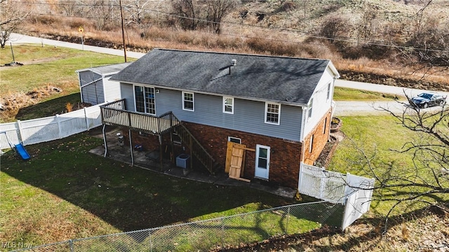 rear view of property with a wooden deck, a yard, and central AC