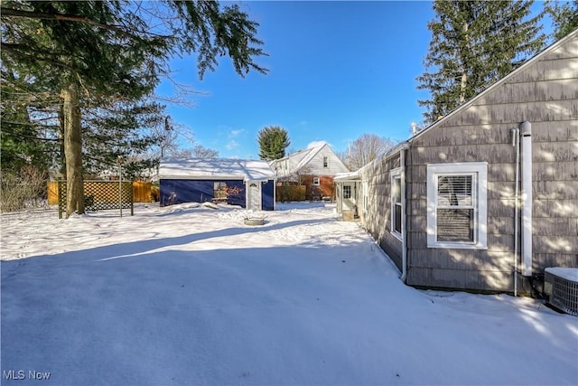 yard layered in snow with central air condition unit