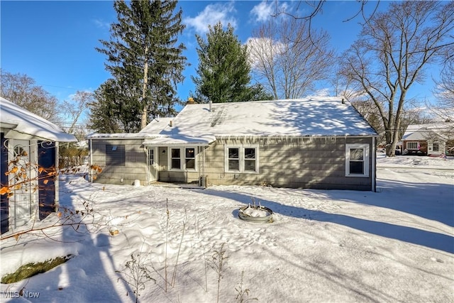 snow covered house with a fire pit