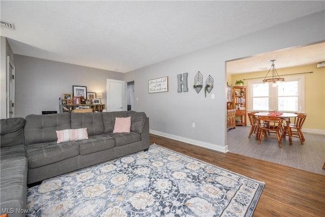 living room featuring an inviting chandelier and wood-type flooring