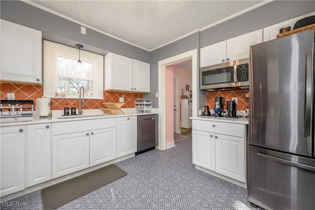 kitchen featuring white cabinets, decorative light fixtures, stainless steel appliances, sink, and ornamental molding