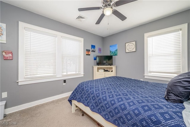 bedroom with ceiling fan, multiple windows, and carpet flooring