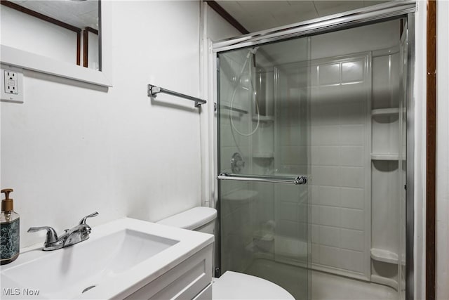 bathroom featuring toilet, vanity, and a shower with door