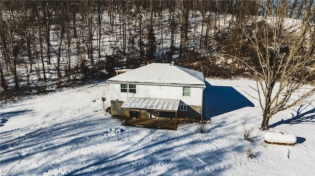 view of snow covered back of property