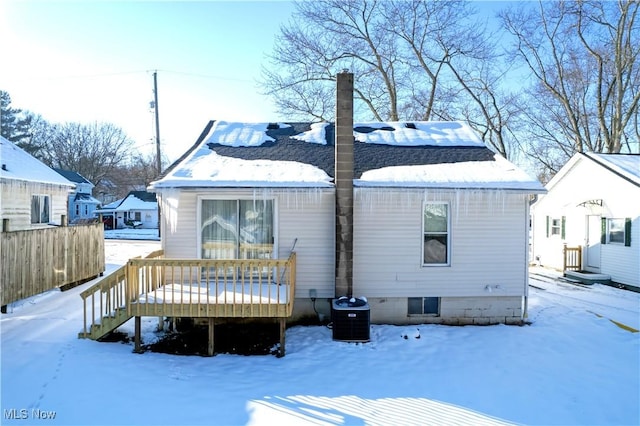 snow covered rear of property featuring a wooden deck and central air condition unit