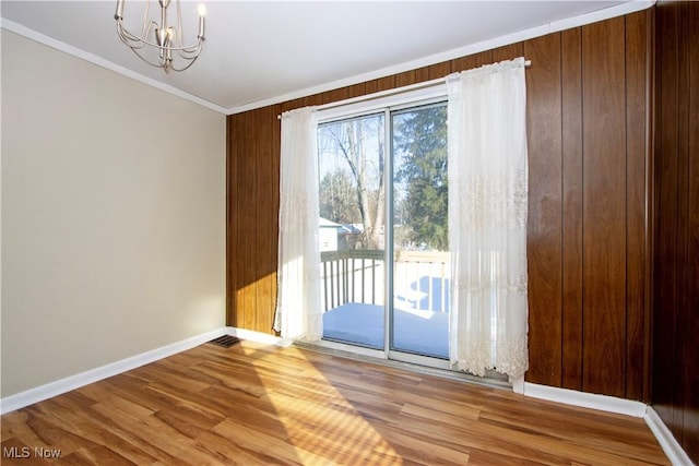 doorway featuring crown molding, hardwood / wood-style flooring, and a notable chandelier