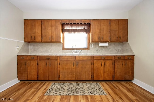 kitchen featuring decorative backsplash, sink, and light hardwood / wood-style flooring