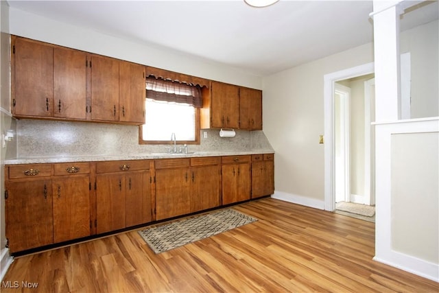 kitchen featuring light hardwood / wood-style floors, sink, and backsplash