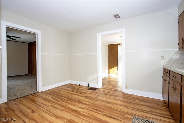 unfurnished dining area featuring ceiling fan and light wood-type flooring